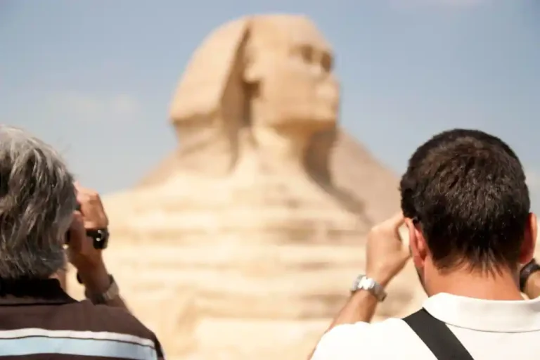 Couple of tourists taking pictures of the egyptian Sphinx